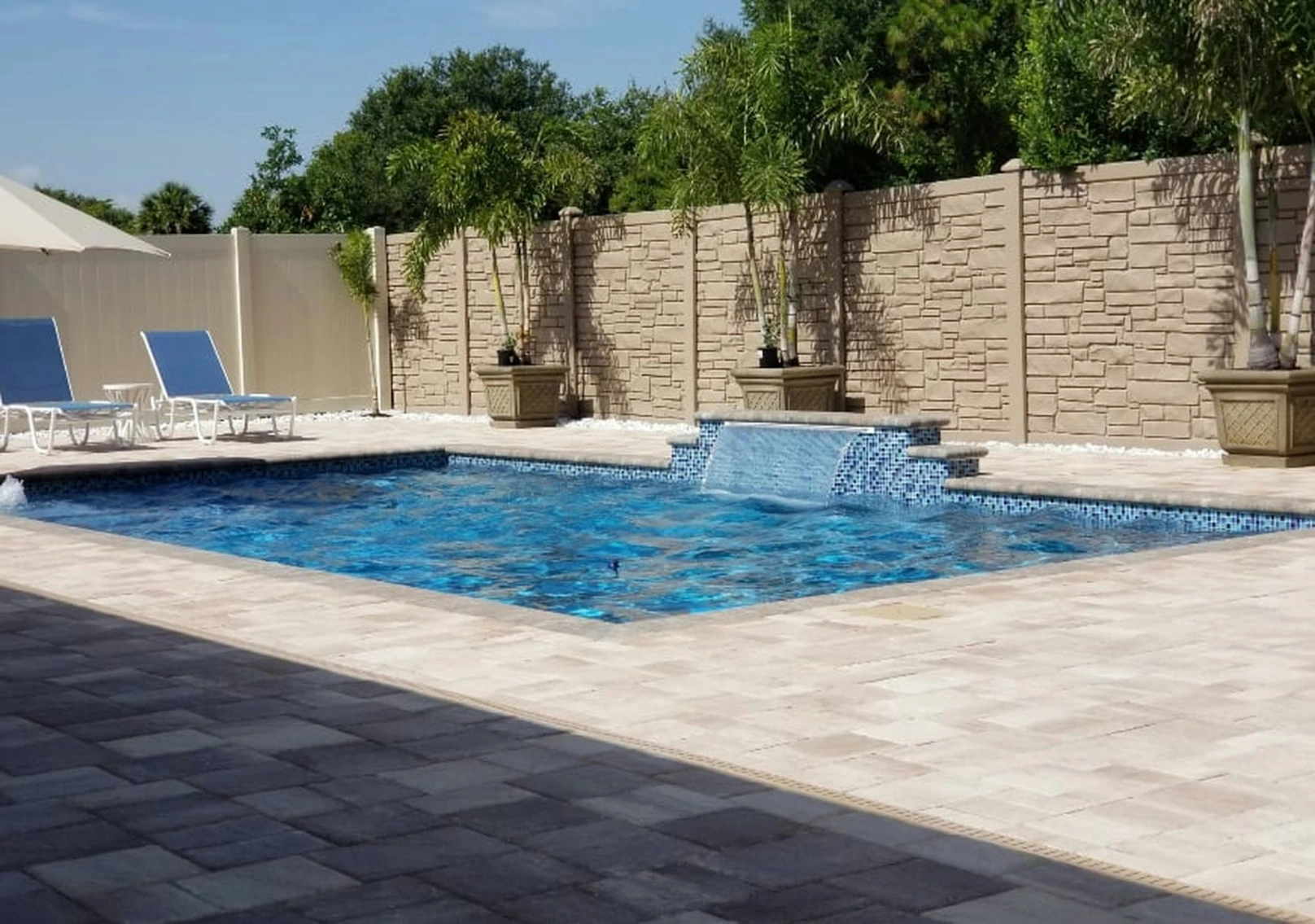 A luxurious pool area with a water feature.